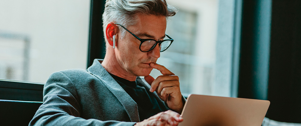 Man reviewing a tablet near a window representing institutional ETF research and asset owner investment trends.